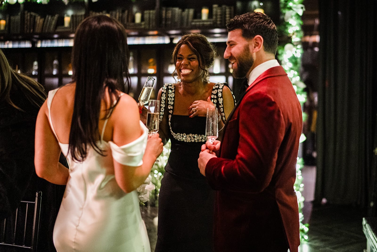 A documentary photograph of a bride and groom laughing with friends during their intimate wedding at Mooo.... Seaport.