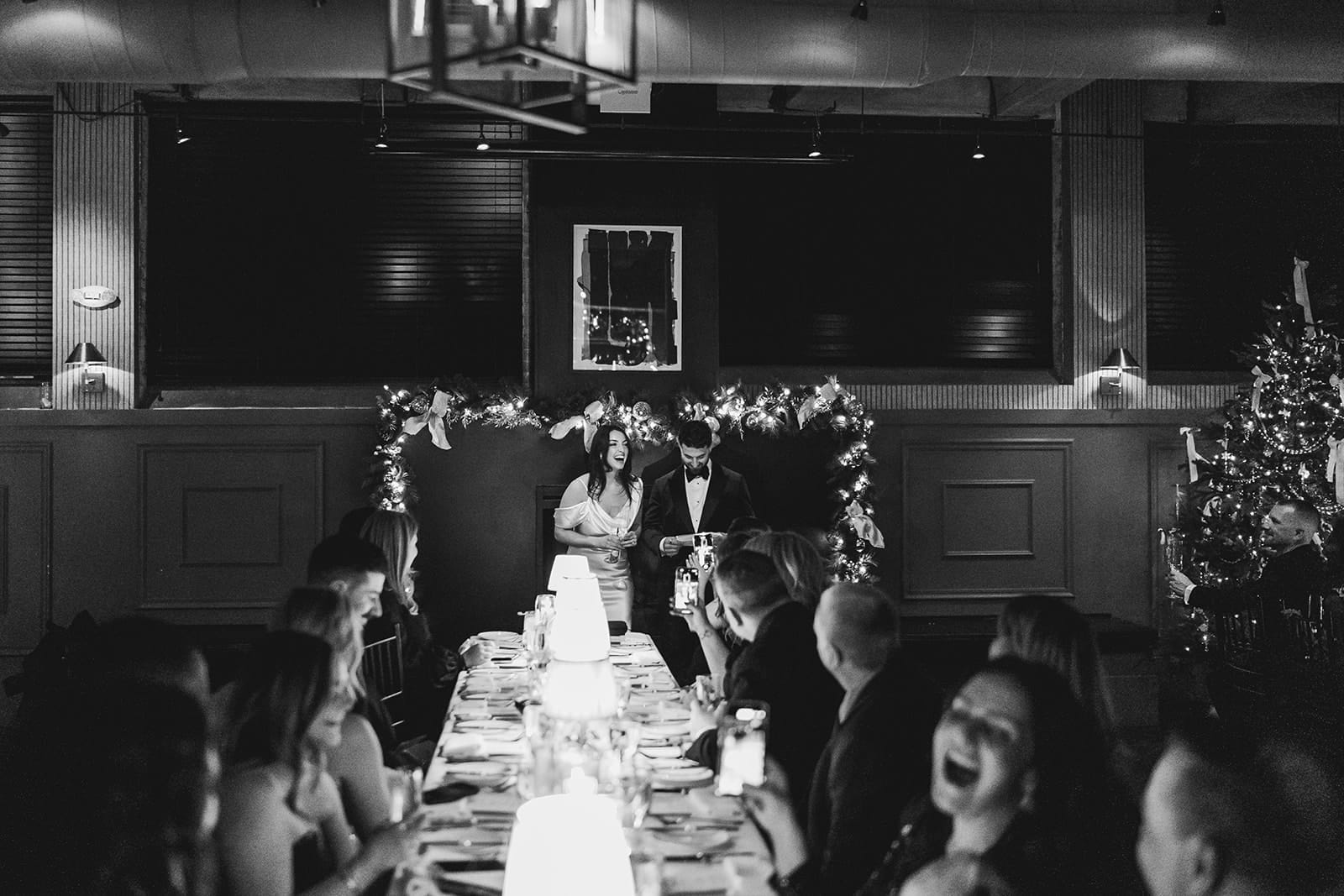 A documentary photograph of a bride and groom giving a toast during their intimate wedding at Mooo.... Seaport.