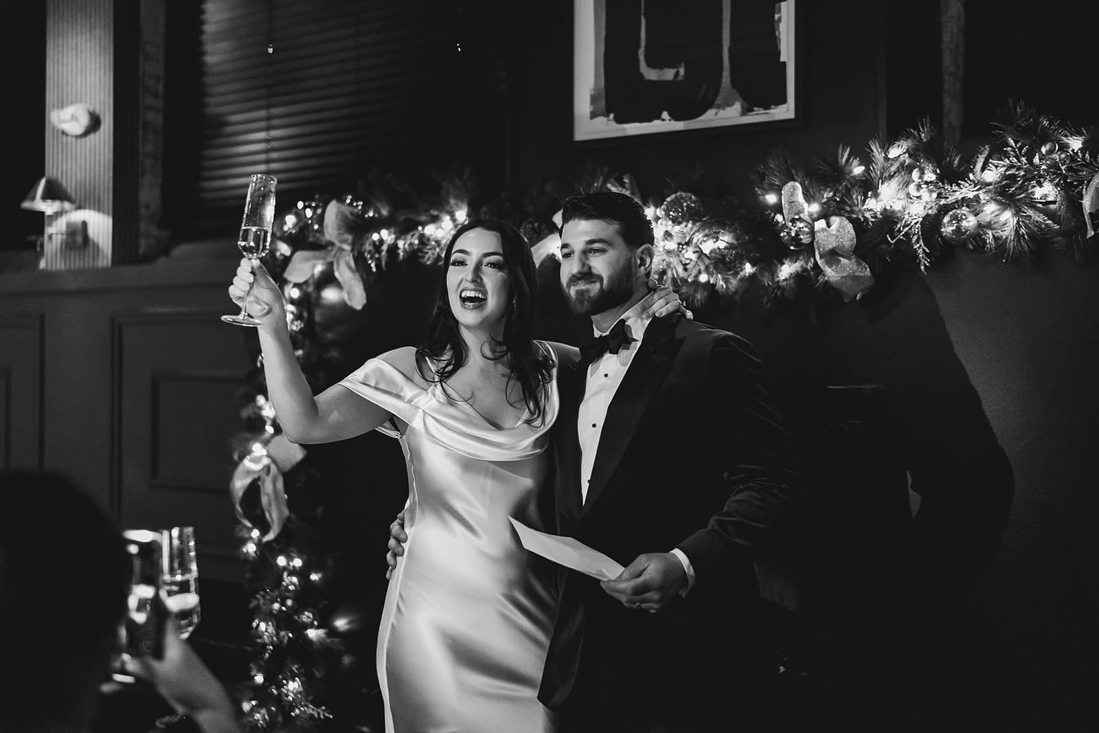 A documentary photograph of a bride and groom giving a toast during their intimate wedding at Mooo.... Seaport.
