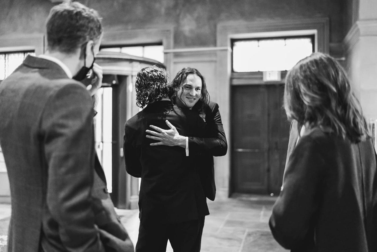 A documentary photograph of a bride and groom hugging guests during their intimate Worcester Art Museum Wedding 