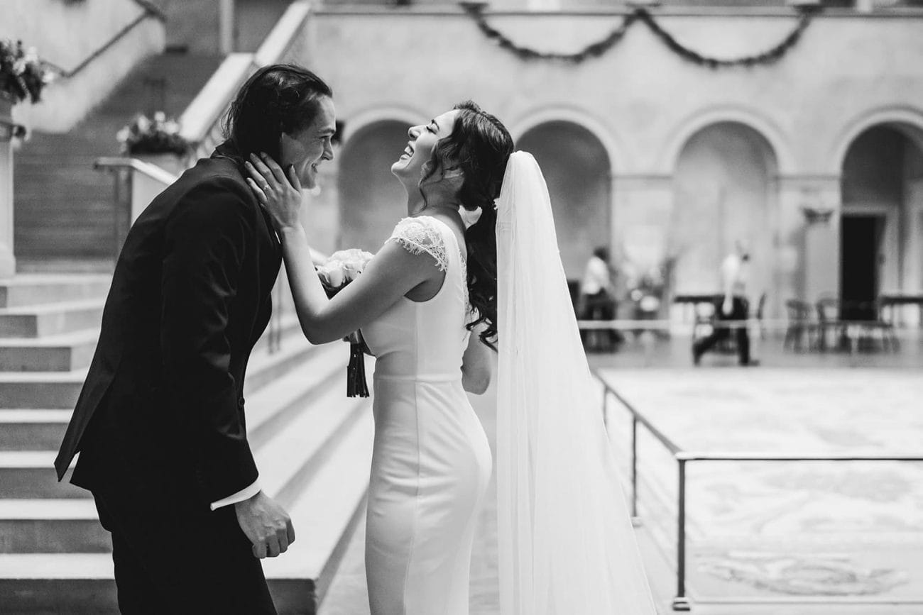 A documentary photograph of a seeing each other and laughing during their intimate Worcester Art Museum Wedding