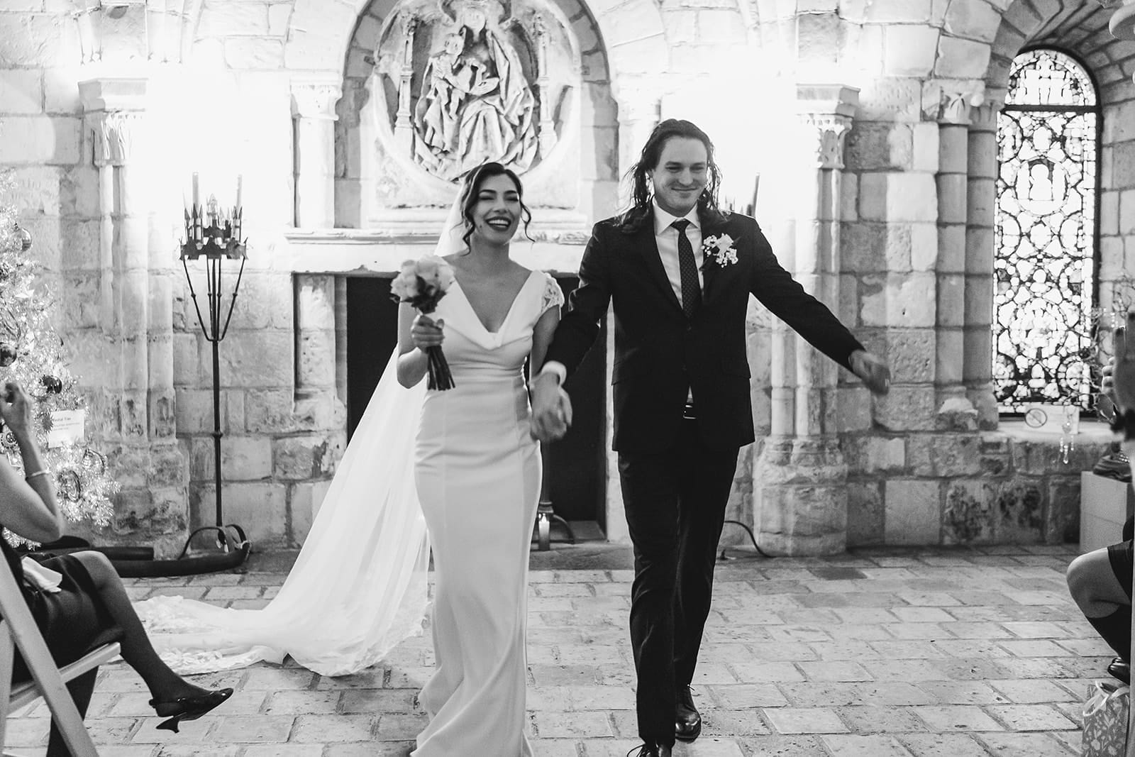 A documentary photograph of a bride and groom waking down the aisle after their intimate Worcester Art Museum Wedding Ceremony