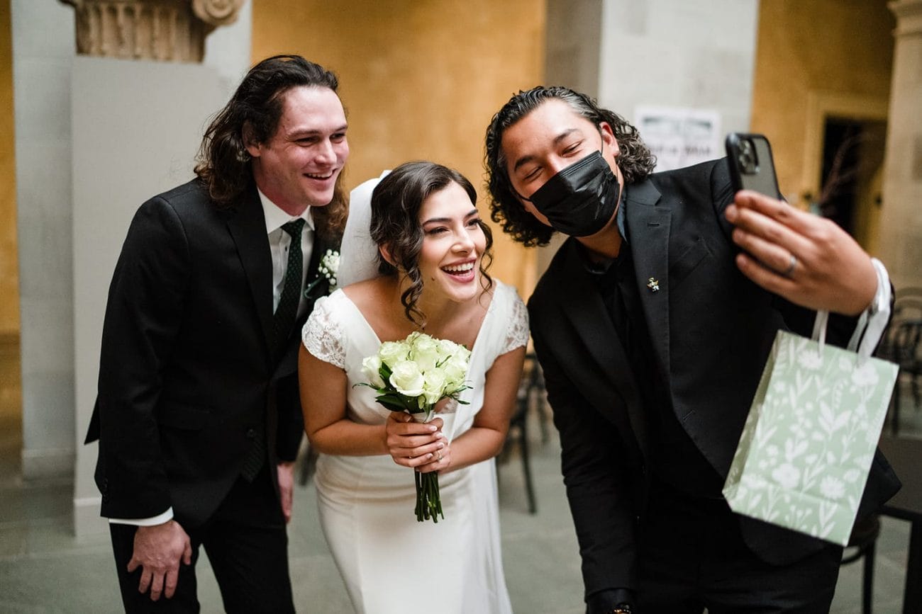A documentary photograph of a bride and groom saying hi to family on zoom during their intimate Worcester Art Museum Wedding 