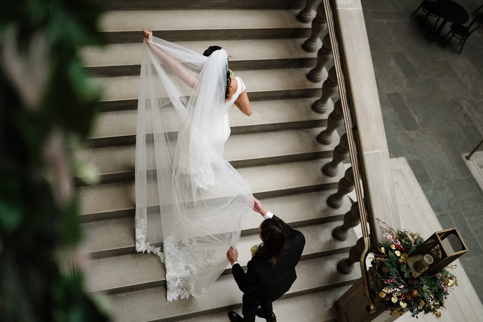 A documentary photograph of a bride and groom walking upstairs to the art galleries during their intimate Worcester Art Museum Wedding