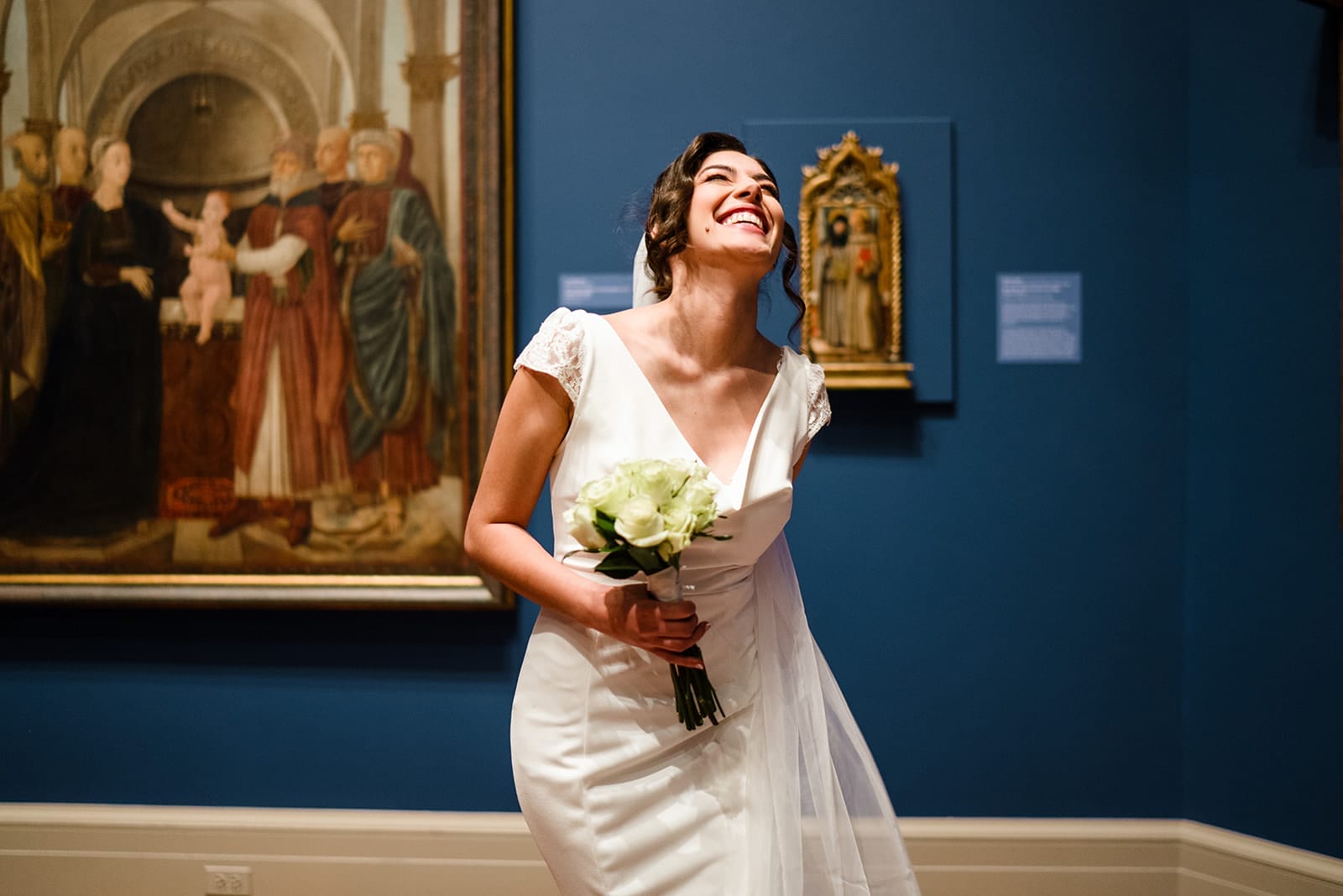 A documentary photograph of a bride laughing in the art galleries during their intimate Worcester Art Museum Wedding