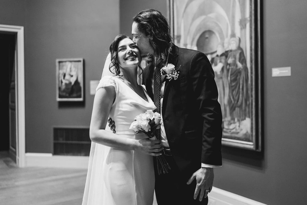 A documentary photograph of a bride and groom spending time in the art galleries during their intimate Worcester Art Museum Wedding 