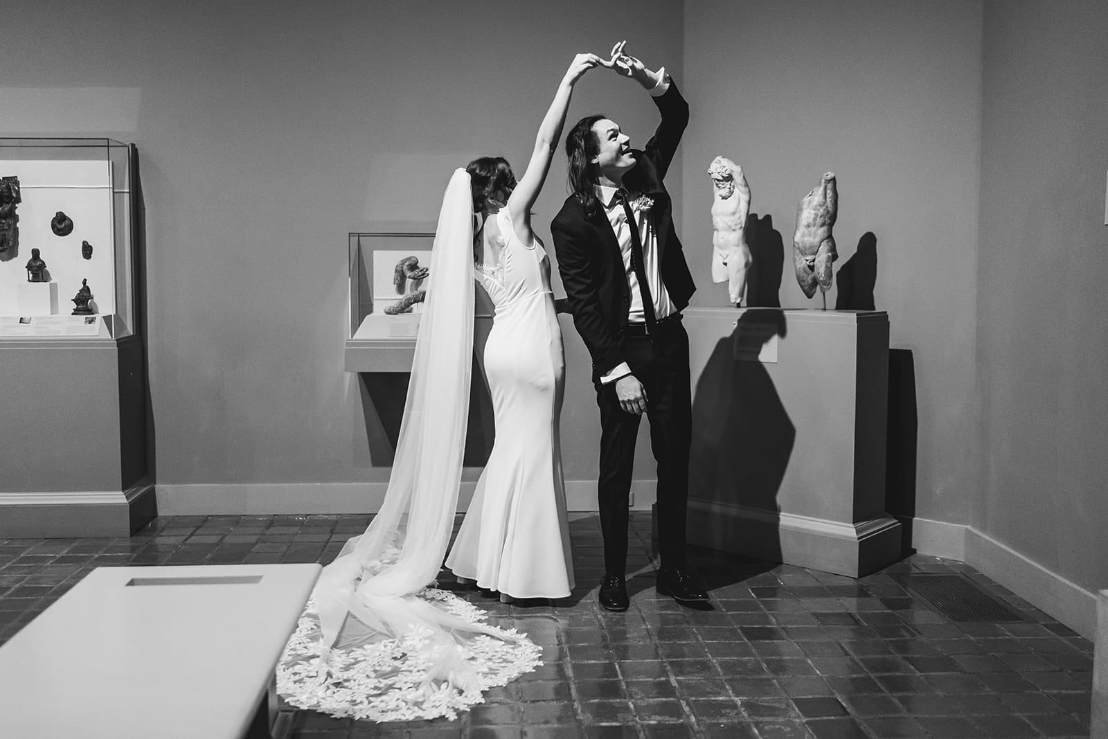 A documentary photograph of a bride and groom spending time in the art galleries during their intimate Worcester Art Museum Wedding