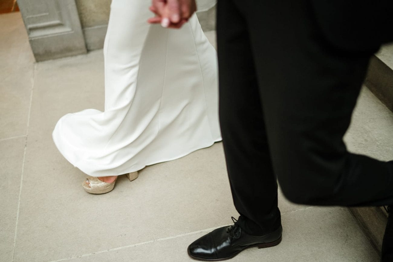A documentary photograph of a bride and groom walking down the stairs during their intimate Worcester Art Museum Wedding 