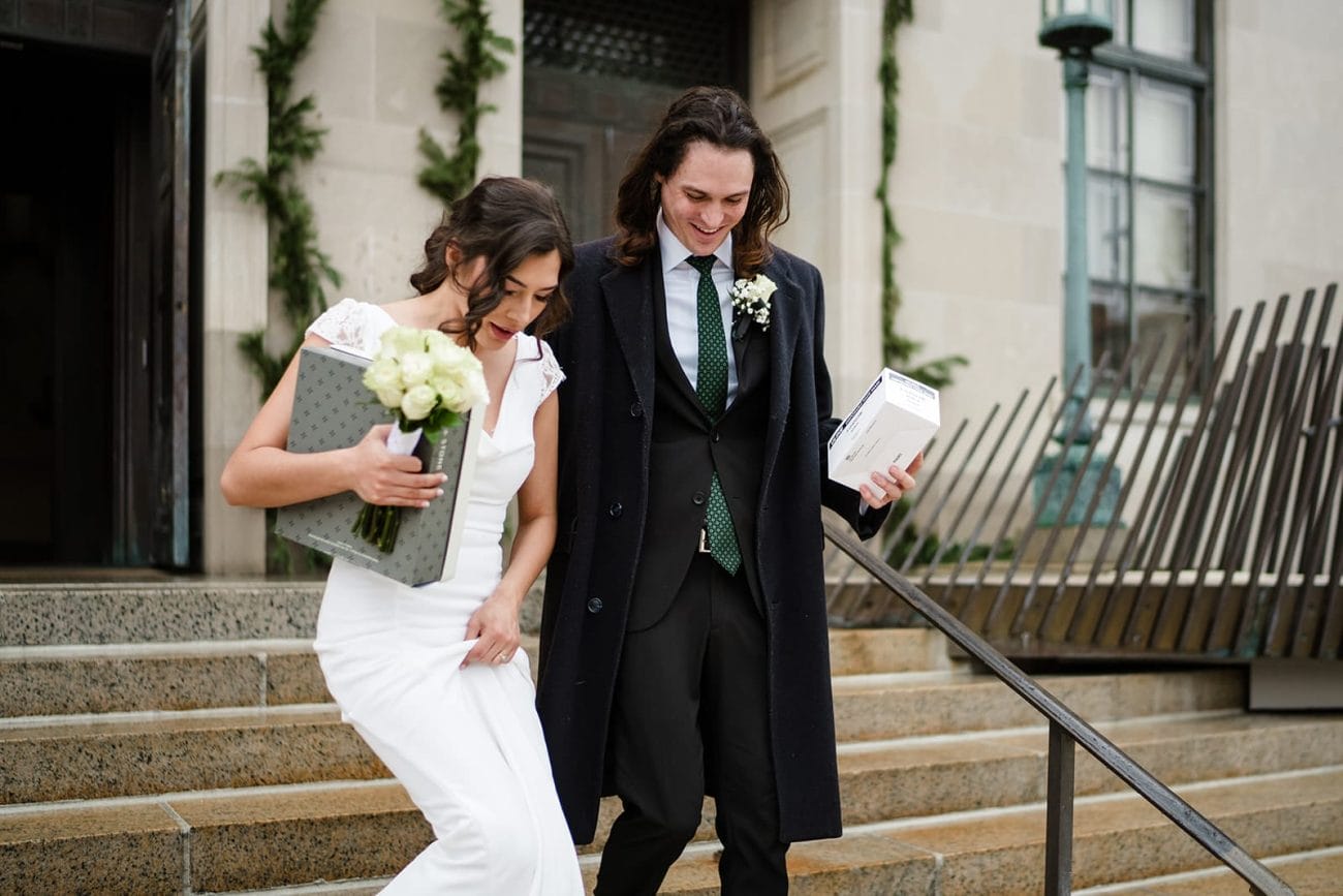 A documentary photograph of a bride and groom walking down the stairs during their intimate Worcester Art Museum Wedding 