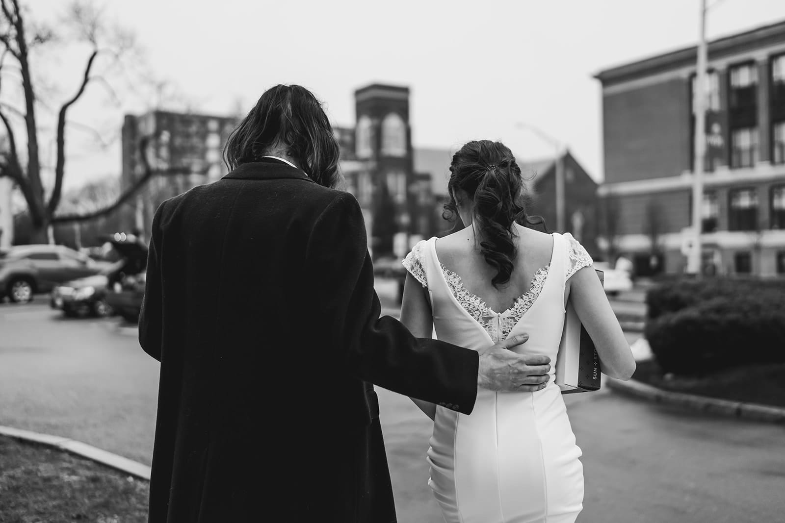 A documentary photograph of a bride and groom heading outside during their intimate Worcester Art Museum Wedding