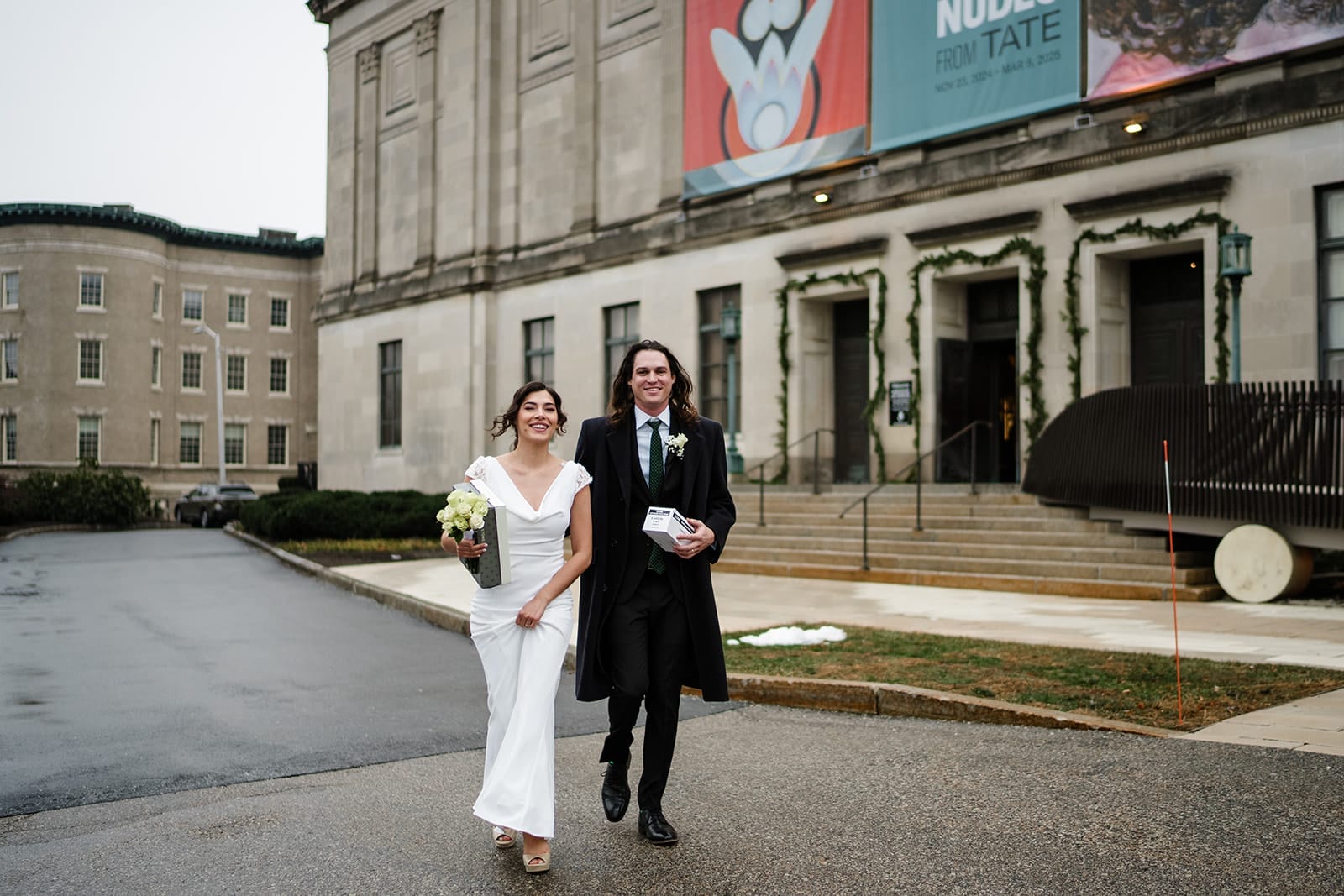 A documentary photograph of a bride and groom heading outside during their intimate Worcester Art Museum Wedding