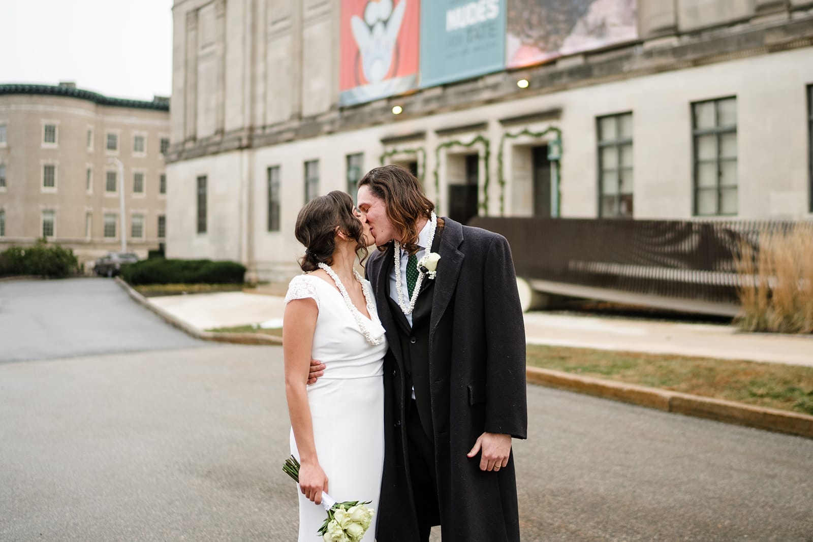 A documentary photograph of a bride and groom kissing outside during their intimate Worcester Art Museum Wedding