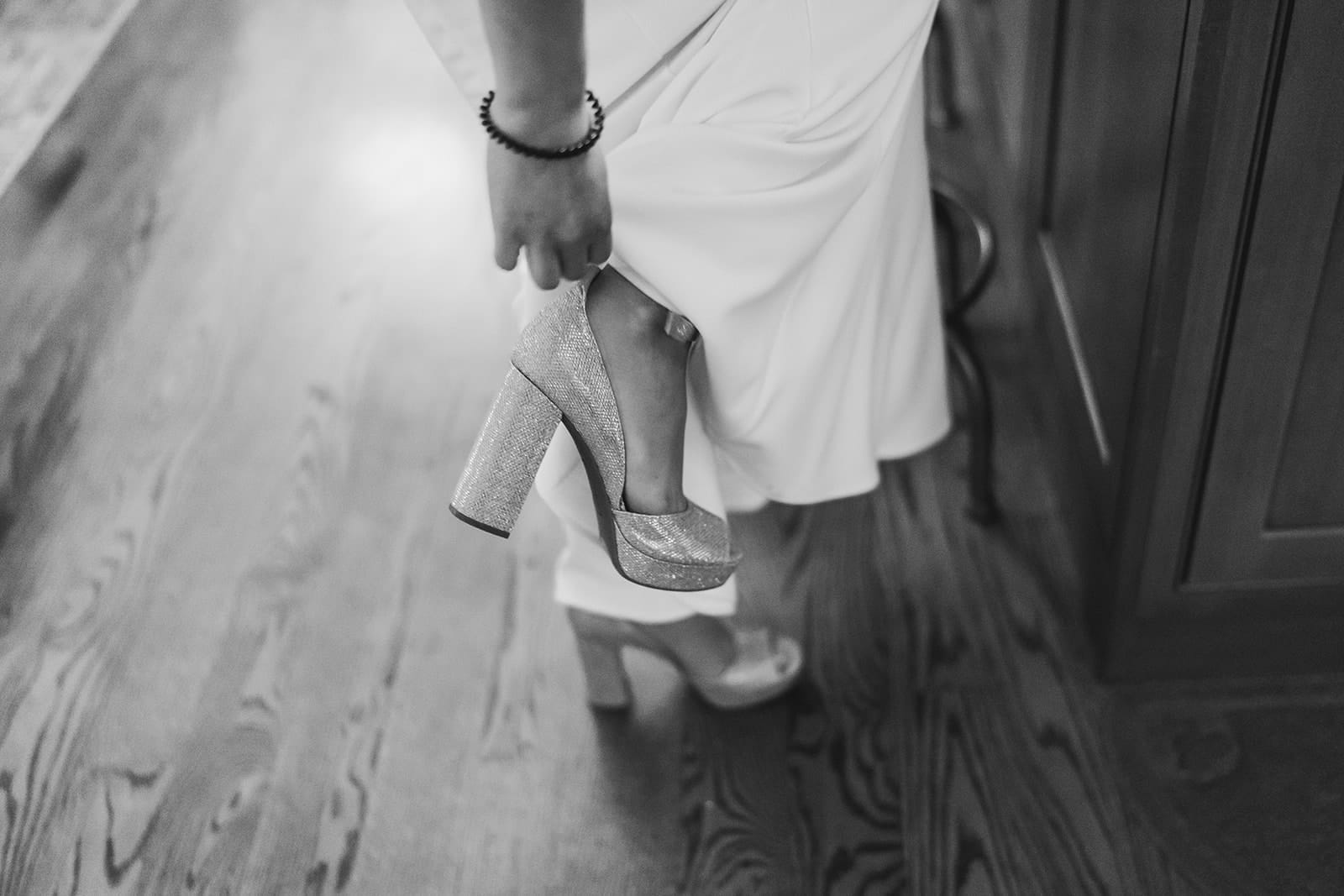 A documentary photograph of a bride taking off her shoes for their in home celebration after their intimate Worcester Art Museum Wedding ceremony