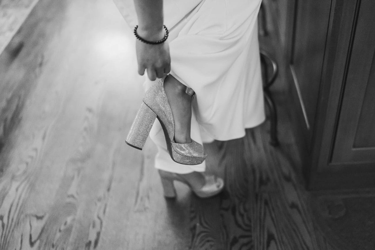A documentary photograph of a bride taking off her shoes for their in home celebration after their intimate Worcester Art Museum Wedding ceremony