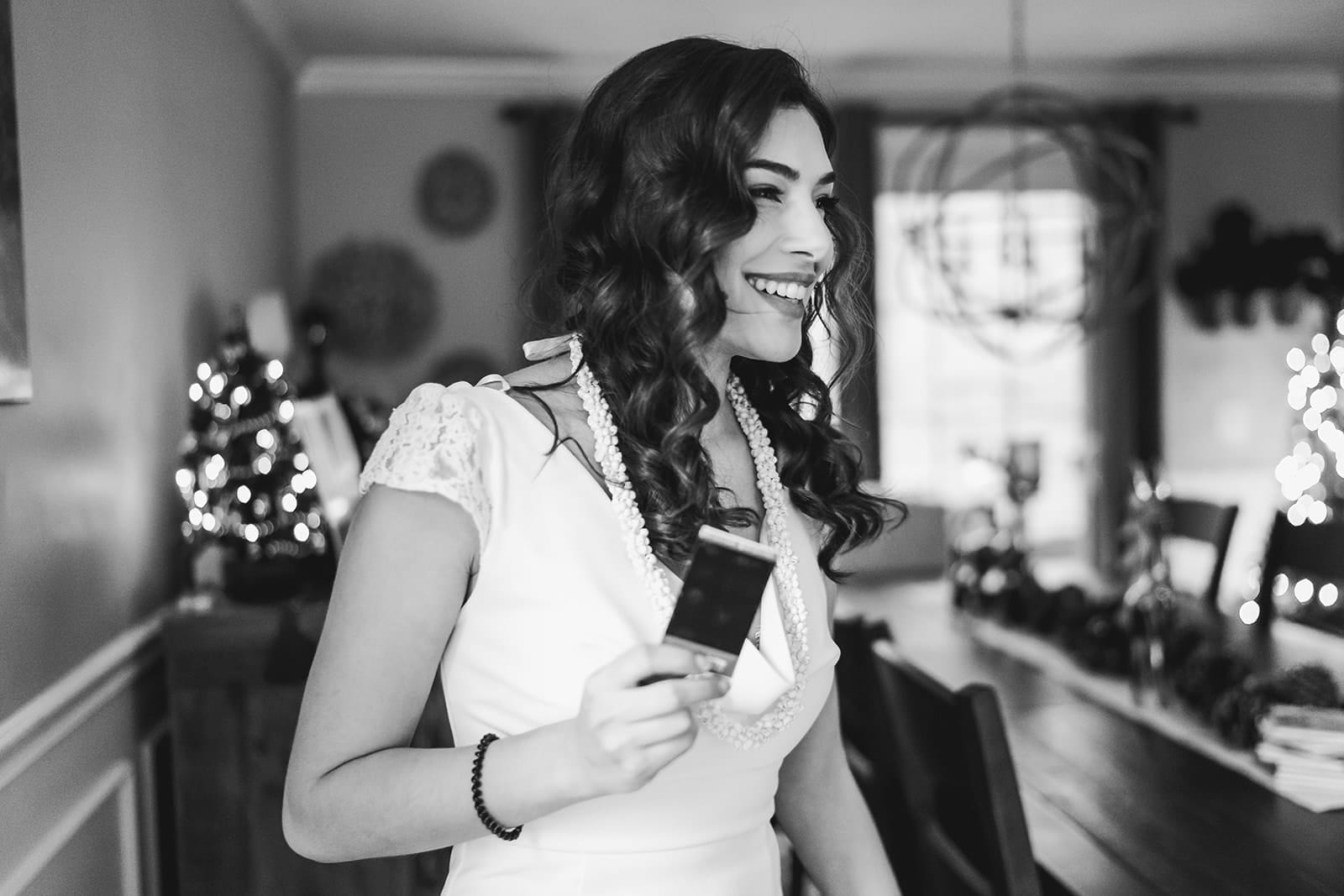 A documentary photograph of a bride laughing during a in home celebration after their intimate Worcester Art Museum Wedding ceremony