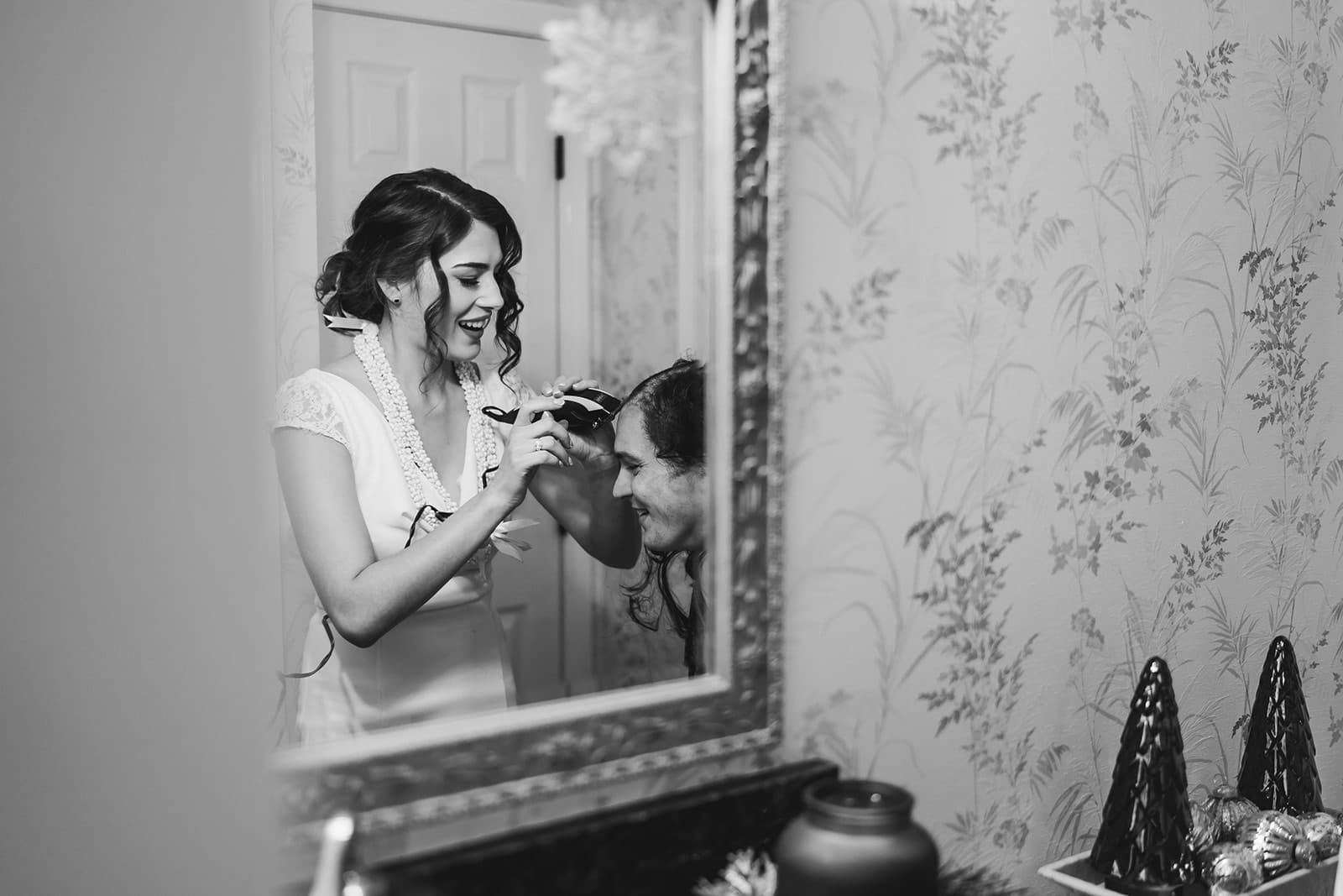 A documentary photograph of a bride shaving a groom's head before cancer treatment during a in home celebration after their intimate Worcester Art Museum Wedding ceremony